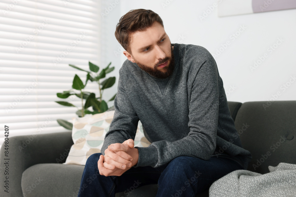 Loneliness concept. Sad man sitting on sofa at home Loneliness concept. Sad man sitting on sofa at home