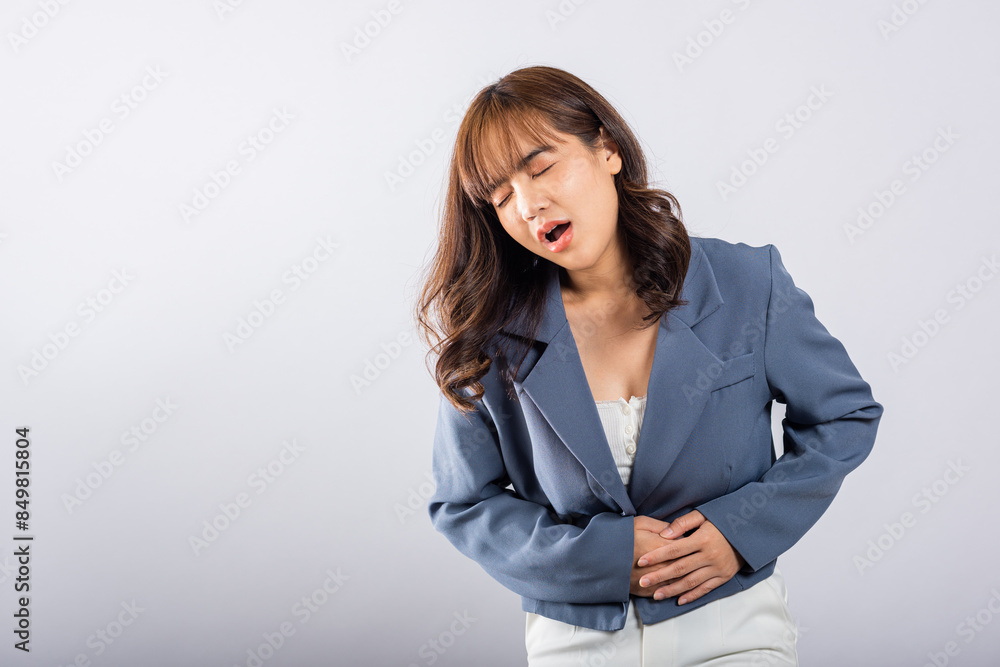 Portrait of Asian beautiful young woman has stomachache, female abdominal pain suffering from stomach ache, studio shot isolated on white background, period pain, Health and medical gastritis concept Portrait of Asian beautiful young woman has stomachache, female abdominal pain suffering from stomach ache, studio shot isolated on white background, period pain, Health and medical gastritis concept