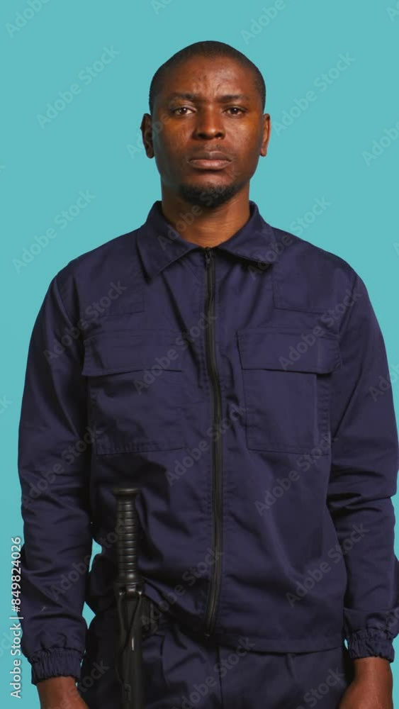 Vertical video Security guard tasked with preventing criminal activity and detaining suspects stealing, damaging property, or performing other crimes. Portrait of intimidating bodyguard, studio Vertical video Security guard tasked with preventing criminal activity and detaining suspects stealing, damaging property, or performing other crimes. Portrait of intimidating bodyguard, studio