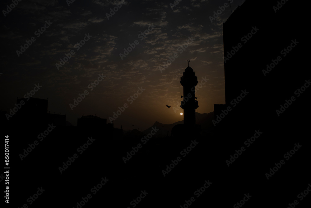 Fototapeta premium Silhouette of mosque minaret in the morning in Makkah city, Saudi Arabia