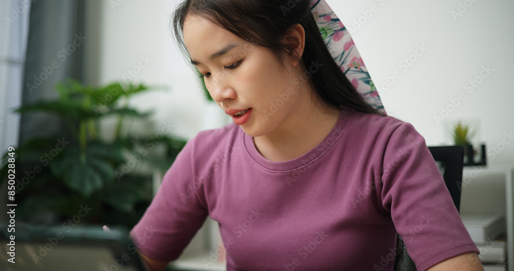 Portrait of Young asian businesswoman having a video conference on digital tablet and writing on note at home office, online meeting Portrait of Young asian businesswoman having a video conference on digital tablet and writing on note at home office, online meeting