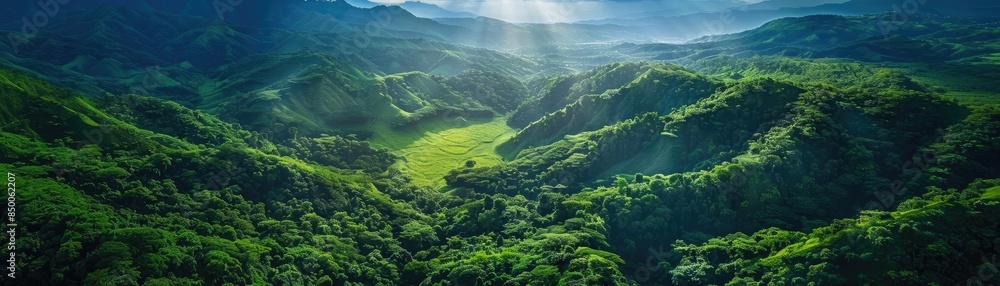Fototapeta premium A breathtaking aerial view of lush green mountains and valleys bathed in sunlight, showcasing the beauty of nature and scenic landscapes.
