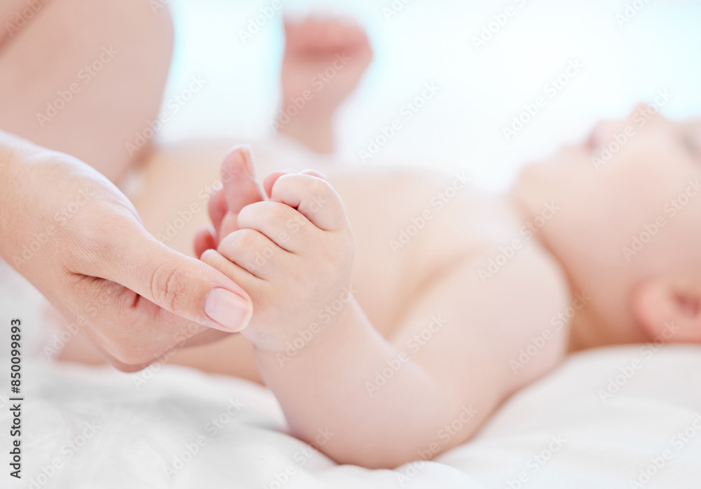 Mother, baby and holding hands for trust with love relationship and care for bonding together on bed. Zoom, newborn kid and mom with touch fingers for security or safety and connection in family home Mother, baby and holding hands for trust with love relationship and care for bonding together on bed. Zoom, newborn kid and mom with touch fingers for security or safety and connection in family home