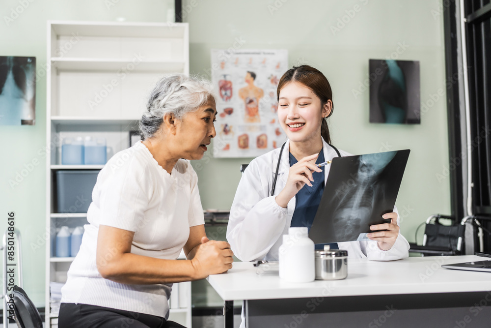 A young Asian female nurse providing healthcare services at her desk, caring for an elderly woman patient. They discuss health checklists and medical advice in a professional setting. A young Asian female nurse providing healthcare services at her desk, caring for an elderly woman patient. They discuss health checklists and medical advice in a professional setting.