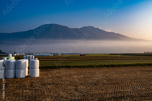 熊本県　阿蘇山を背景に朝霧と南阿蘇村の田園風景 photo