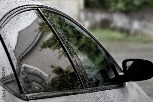 Automobile rear view mirror in water drops after rain. close up of water droplets on the car side mirror, windows with empty copy space, causing danger while using the car