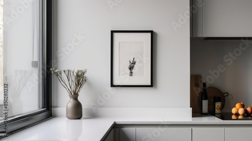 A minimalist kitchen nook with a small, unadorned frame holding a black and white still life photograph