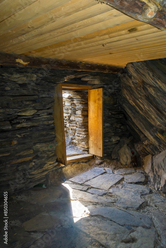 Inside one of the village rooms. Low doorway, wooden door. Medieval village Mutso. photo