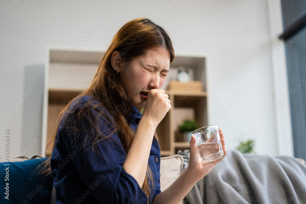 woman sitting on sofa covered with blanket freezing blowing running nose got fever caught cold, holding pills and glass of water. woman sitting on sofa covered with blanket freezing blowing running nose got fever caught cold, holding pills and glass of water.