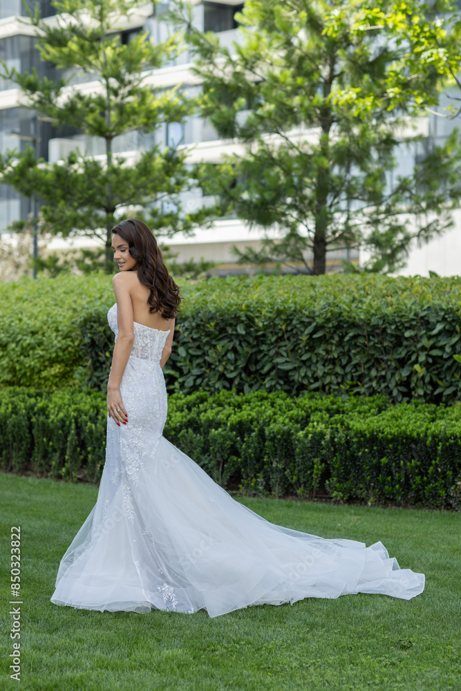 Beautiful young bride in white wedding dress posing outdoor in the park Beautiful young bride in white wedding dress posing outdoor in the park