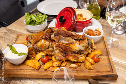 lamb chops served on a wooden board with potatoes