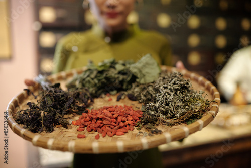 Fotografie Close-up of apothecary holding tray with dried herbs to use them in traditional