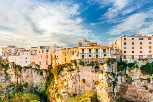 scenic travel landscape of beautiful historic town Tropea in Italy with old antique buildings, vintage houses on a high rock cliff above sea and amazing blue sky on background