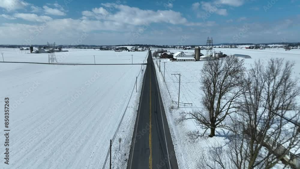 Snowy winter landscape with straight street in rural farm area in USA. Sunny day in winter season. Snowy winter landscape with straight street in rural farm area in USA. Sunny day in winter season.