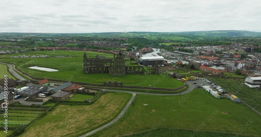 Whitby Abbey Ruins Near Cholmley House In Whitby, North Yorkshire, UK. River Esk In Background. aerial pullback shot Whitby Abbey Ruins Near Cholmley House In Whitby, North Yorkshire, UK. River Esk In Background. aerial pullback shot