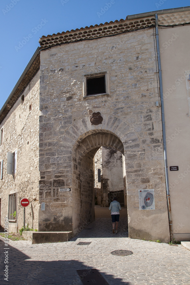 Touriste entrant par une vieille porte du village de Sauzet (Drôme) Touriste entrant par une vieille porte du village de Sauzet (Drôme)