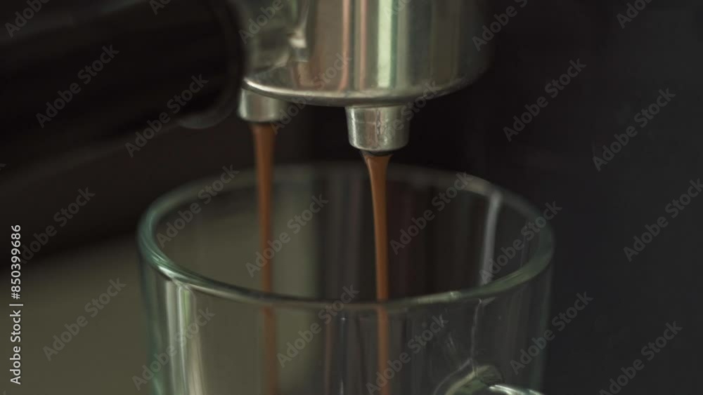 Espresso coffee pours from the metal horn of the coffee machine. An invigorating morning drink. Macro Espresso coffee pours from the metal horn of the coffee machine. An invigorating morning drink. Macro