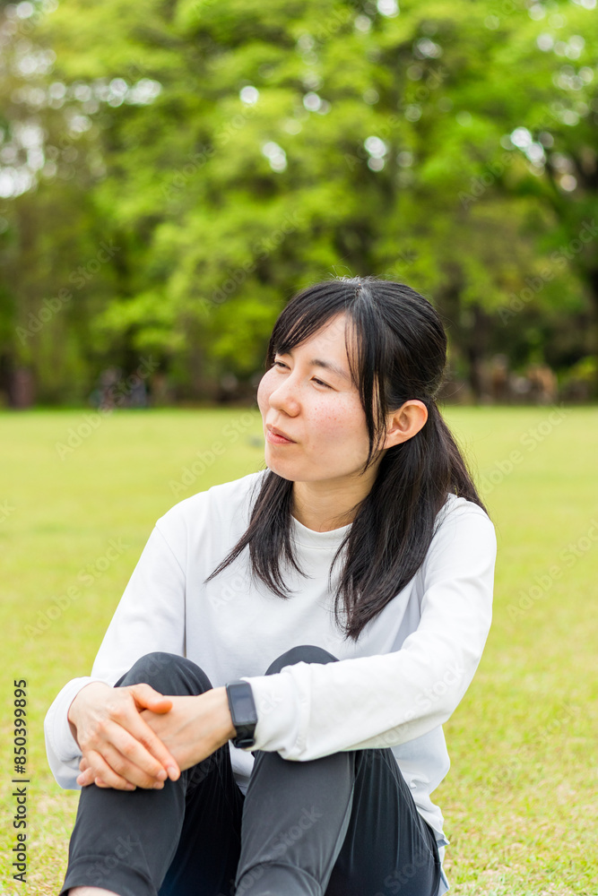 芝生に座る20代女性