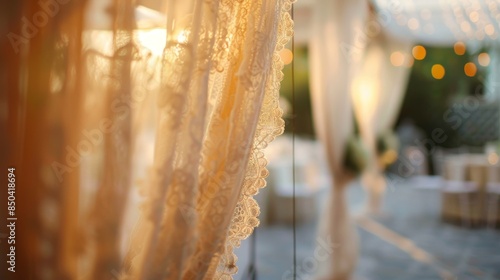 A glimpse of the outdoor reception through the lacy curtains of a tent creating a romantic filter.