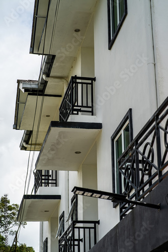 Corner of classical white building with windows and balconies downtown of Cameron Highlands, Malaysia.