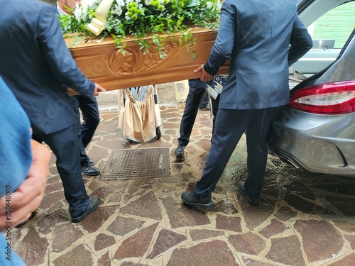 Hearse with gravediggers carrying the coffin photo