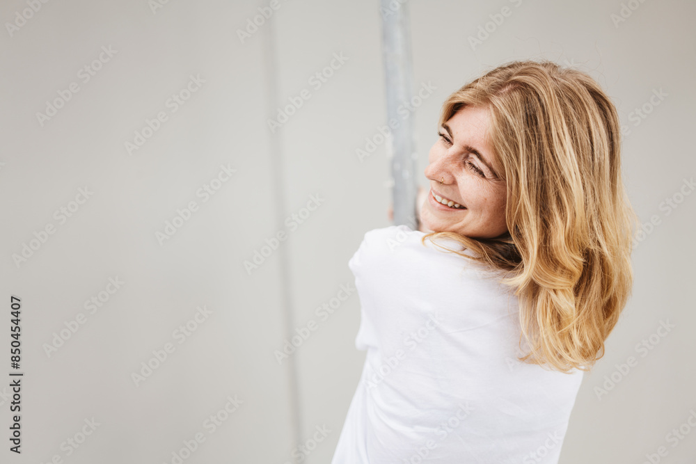 Portrait of a cheerful woman looking over her shoulder, smiling. She appears joyful, creating a positive and happy atmosphere. Portrait of a cheerful woman looking over her shoulder, smiling. She appears joyful, creating a positive and happy atmosphere.