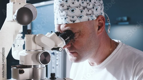 A doctor uses a microscope during eye surgery or diagnosis, cataract treatment and diopter correction. A surgeon looks through a microscope at a patient's eyes in the operating room. photo