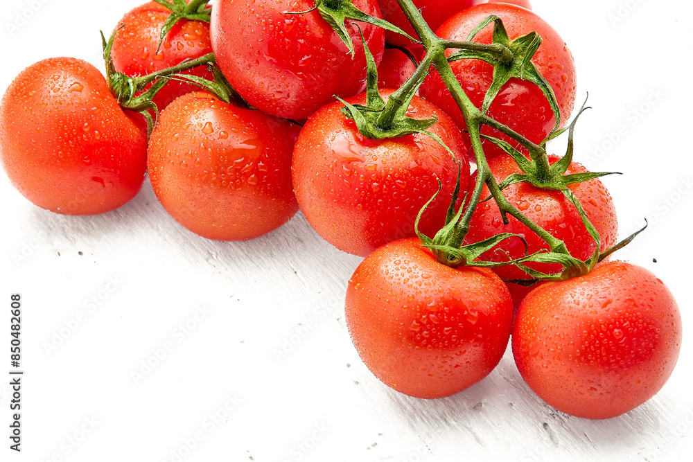 Ripe cherry tomatoes with drops of water on white wooden surface. Close-up of cherry tomatoes. Ripe cherry tomatoes with drops of water on white wooden surface. Close-up of cherry tomatoes.