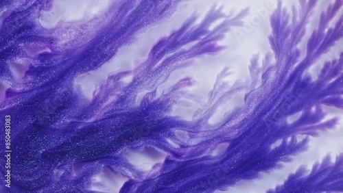 Purple and pink swirls in an acrylic pour painting create intricate patterns on a white background. The fluidity of the liquid paint creates delicate lines that resemble fractal structures.