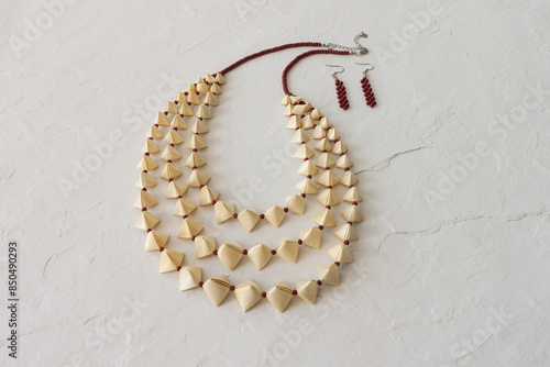 Straw necklace and beaded earrings on a white background. Small depth of field. Straw weaving