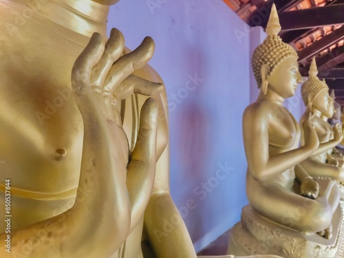 Close up of golden hand of Buddha statue in Phra Borommathat Sawi Temple.