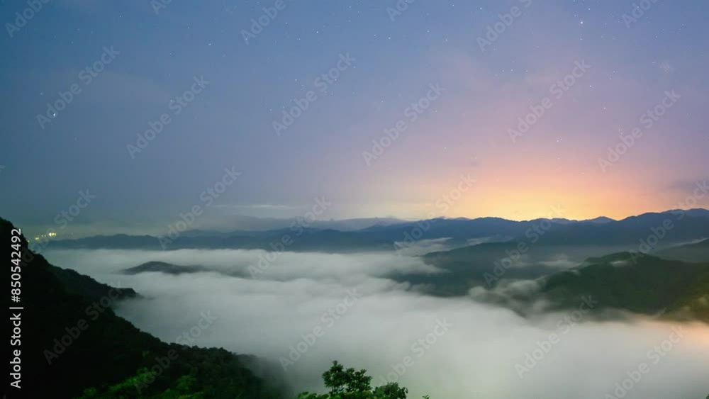 The orange-red light in the distance, the sea of clouds under the starry sky. View of the mountains surrounding Emerald Reservoir. Xindian District, Taiwan. The orange-red light in the distance, the sea of clouds under the starry sky. View of the mountains surrounding Emerald Reservoir. Xindian District, Taiwan.