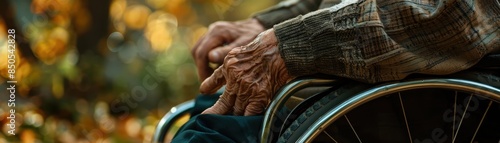 an older man's hand on a wheelchair wheel