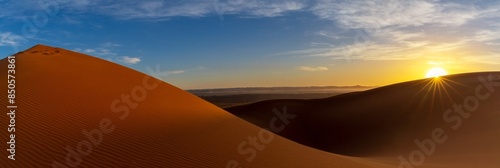 panorama view of the sand dunes at Erg Chebbi in Morocco at sunset with a sunstar