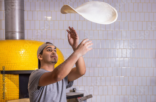 Foto Chef tosses the pizza dough into the air