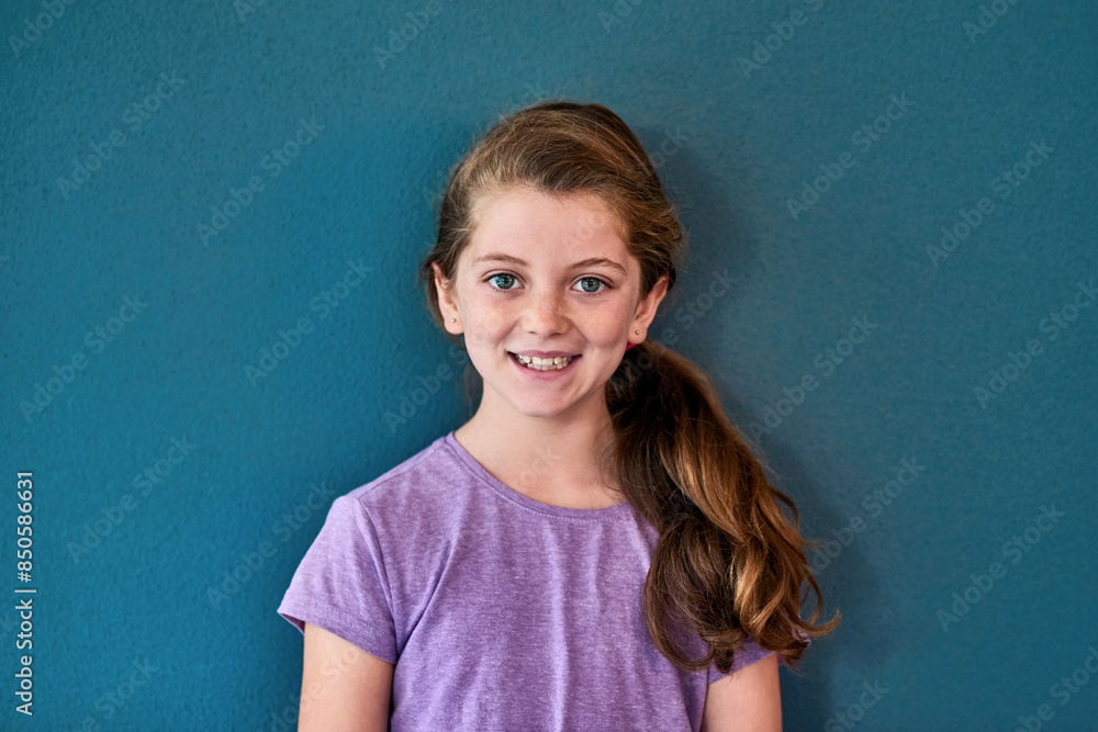 Girl, student and portrait with smile in studio, happiness for education in New York City. Female child, elementary grade and cheerful for knowledge in classroom, back to school on blue background Girl, student and portrait with smile in studio, happiness for education in New York City. Female child, elementary grade and cheerful for knowledge in classroom, back to school on blue background