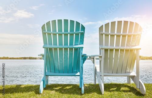 Blue sky, sunshine and chair on grass at lake for environment, scenery and relax in summer. Clouds, nature and bench on outdoor field by water for sitting view, holiday and vacation in California