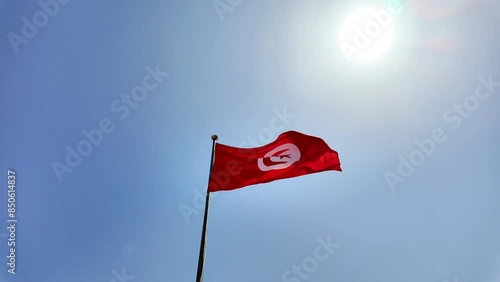 Tunisia flag waving on blue sky background, isolated