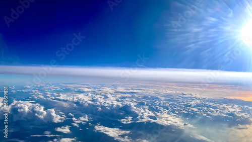 Sunny Sky from Above: A Captivating Scene of the Sunny Sky Viewed from a Plane Window with a Layer of Cumulus Clouds Stretching Across the Horizon