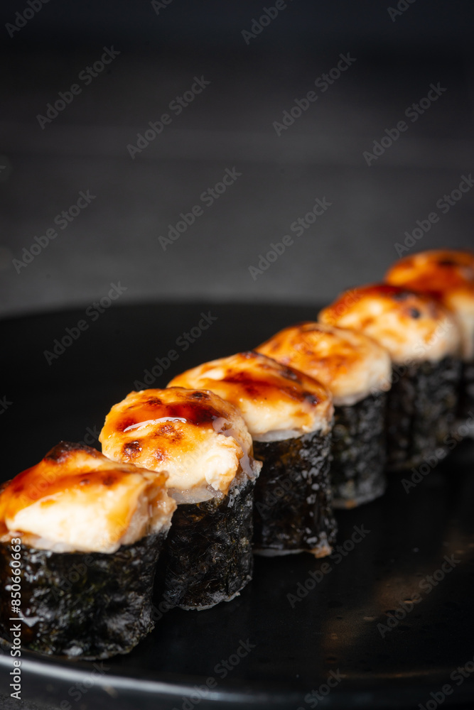 Baked sushi on a black plate Baked sushi on a black plate