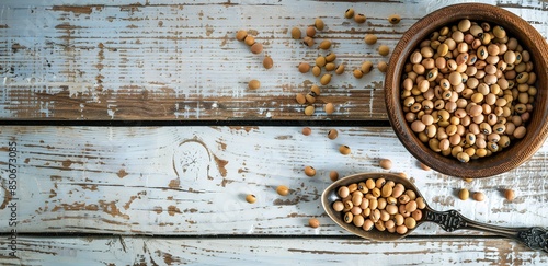 A bowl and spoon containing nuts on a textured wooden table