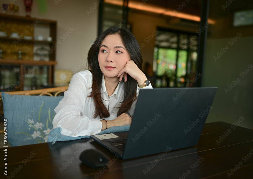 Young Asian business woman is working with a tablet in a coffee shop. Young Asian business woman is working with a tablet in a coffee shop.
