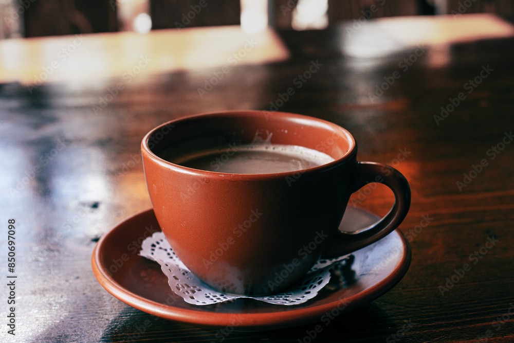 Fresh Americano coffee with milk in traditional brown clay cup on the wooden table Fresh Americano coffee with milk in traditional brown clay cup on the wooden table