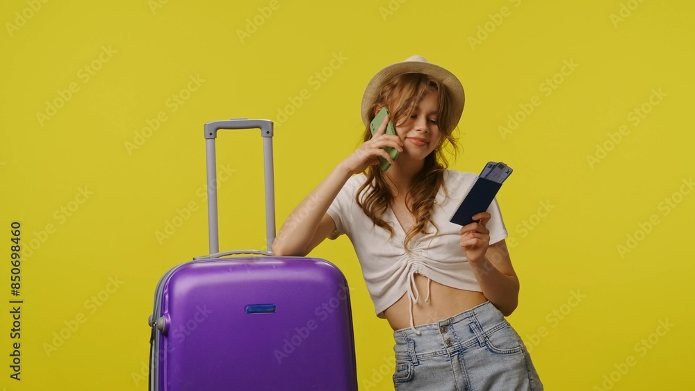 Young woman in casual with suitcase talking on smartphone. Travel, summertime vacation, tourism leisure time concept. Young woman in casual with suitcase talking on smartphone. Travel, summertime vacation, tourism leisure time concept.