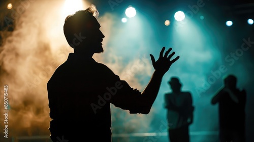 Silhouette of a director giving instructions to the crew under stage lights