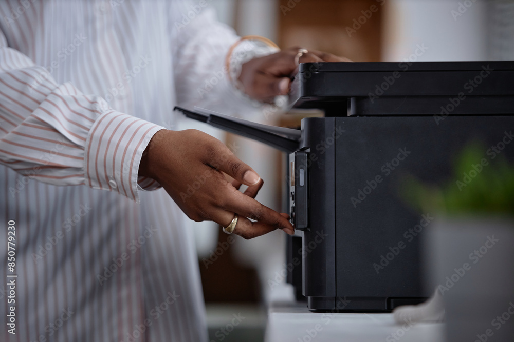 Side view close up on printer and female hands of office worker pressing button on multifunction laser printer in home office or at workplace. Student scanning documents at university, copy space Side view close up on printer and female hands of office worker pressing button on multifunction laser printer in home office or at workplace. Student scanning documents at university, copy space