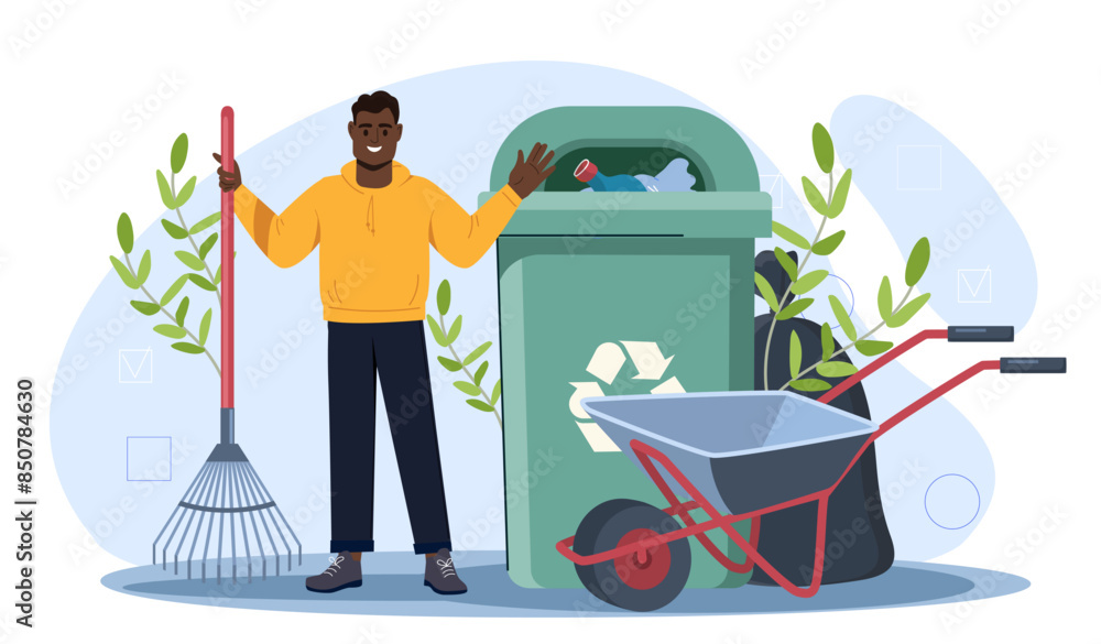 Man picking garbage. Young guy with rake stands near green trashcan