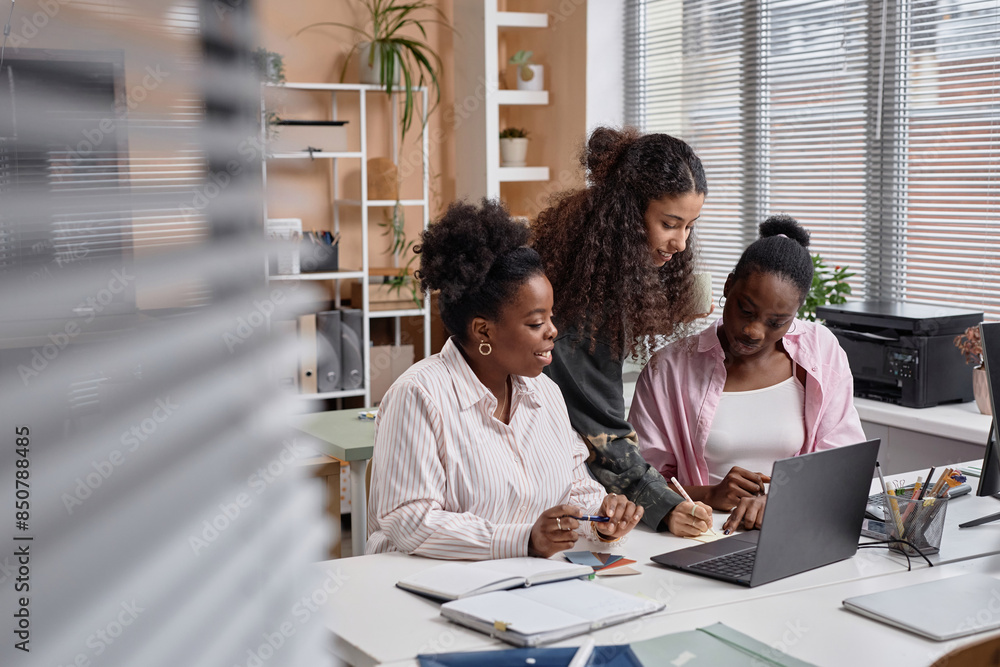 Obraz premium Diverse team of businesswomen collaborating writing notes on paper and discussion issues in office, copy space