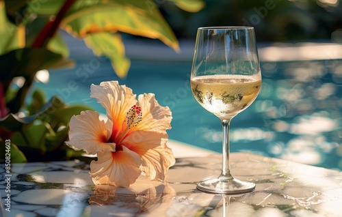 Glass of White Wine by the Pool With a Hibiscus Flower in Tropical Setting