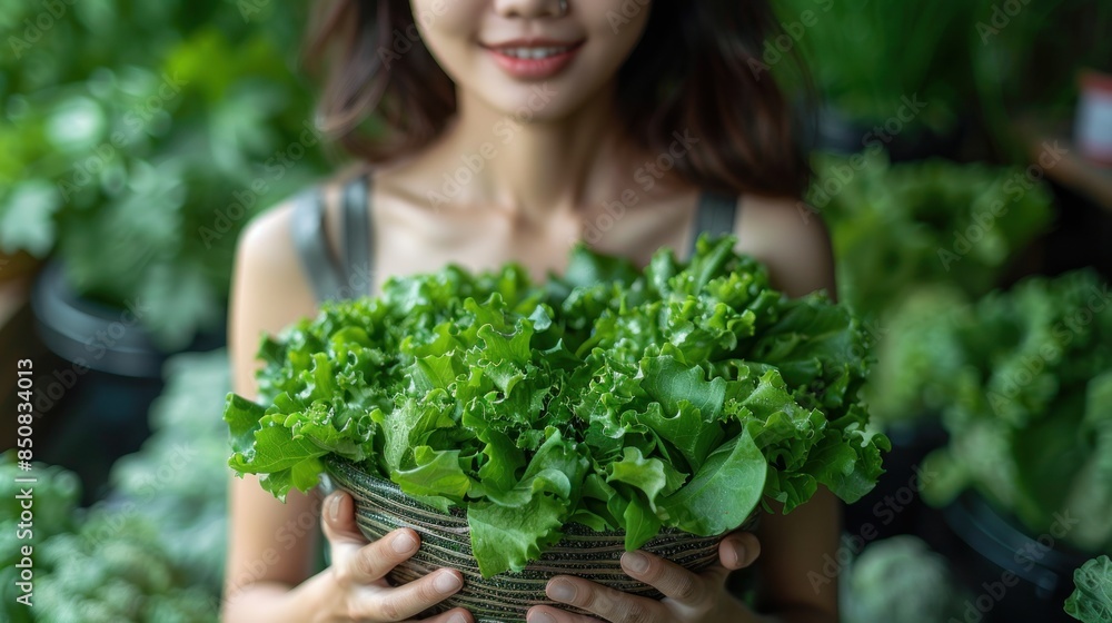 Fototapeta premium Woman Holding Fresh Green Salad in Garden Setting